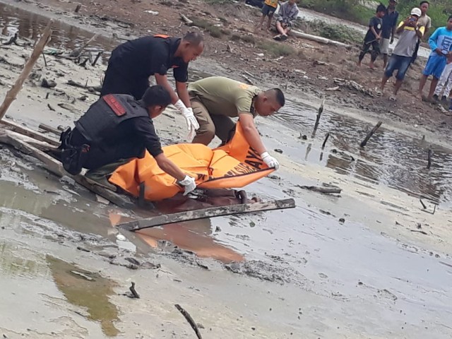 Foto :Petugas mengevakuasi mayat di pinggir sungai Kenjeran.(Rizky)