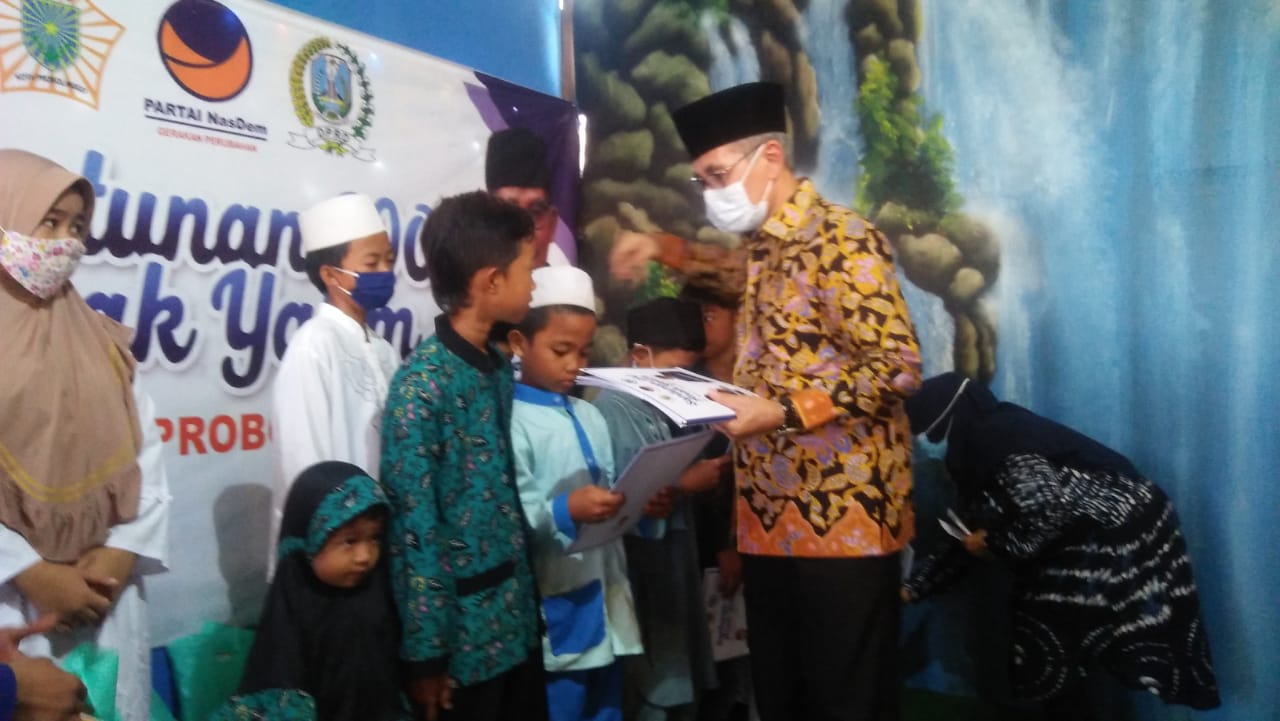 H.Muzamil Syafi'i Ketua Fraksi NasDem DPRD Jawa Timur saat memberikan santunan kepada Yatim Piatu.