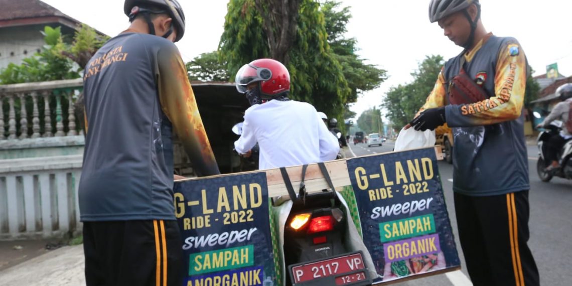 Caption : Pesepeda saat memungut sampah di sepanjang rute gowes