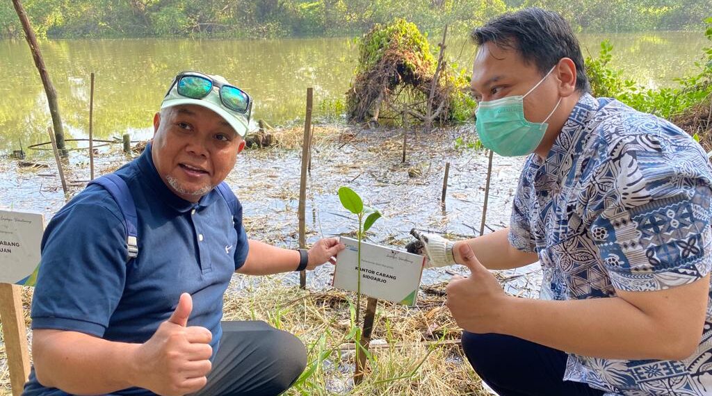 Kepala BPJamsostek Sidoarjo, Novias Dewo Santoso (kiri) secara simbolis menanam bibit Mangrove di ekowisata Mangrove Wonorejo, Surabaya, Senin (8/8/2022) pagi. (ist)