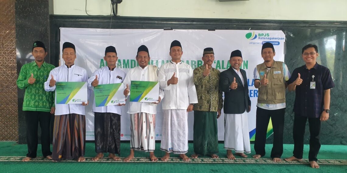 Secara simbolis Takmir, Guru TPQ, Pengurus Masjid Jami' Nurul Islam Sidokerto Buduran, Sidoarjo dengan membawa kartu kepesertaan BPJS Ketenagakerjaan, Jumat (13/8/2022). (ist)