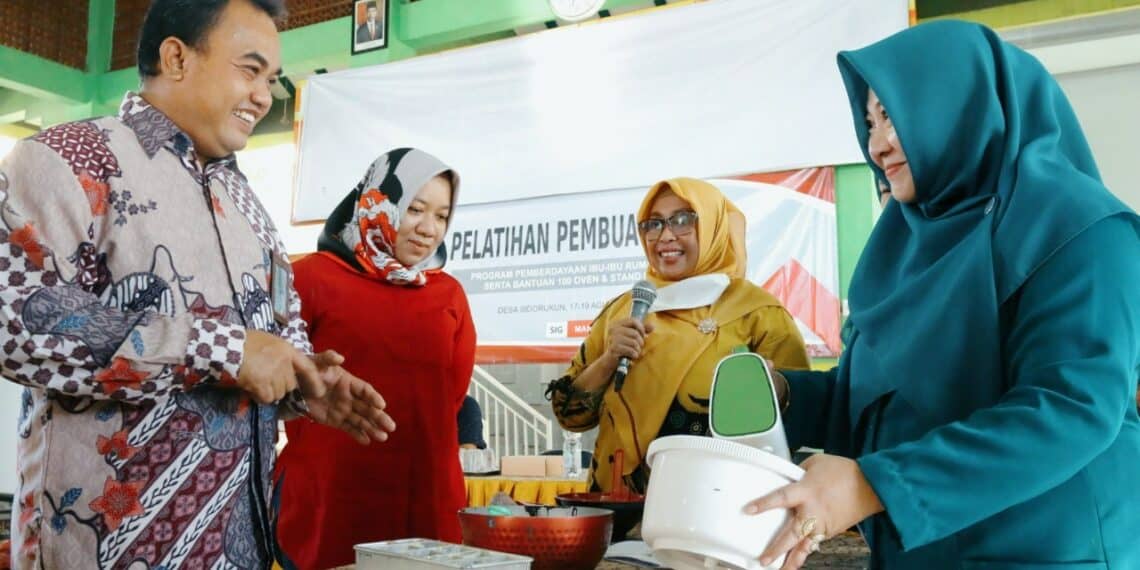 GM of CSR SIG Edy Saraya (kiri) didampingi Kabid Koperasi & Usaha Mikro Dinkop, Usaha Mikro dan Perindag Kab. Gresik, Fransiska Dyah Ayu (2 kiri) melihat praktik pelatihan pembuatan kue di Desa Sidorukun, Jumat (19/8/2022). (ist)