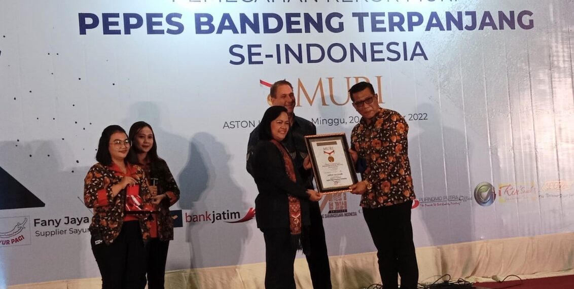 Muri menyerahkan sertipikat pepes bandeng terpanjang pada manager Aston Inn Gresik