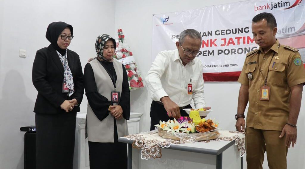 Gedung Baru Bank Jatim Capem Porong Diresmikan, Siap Berikan Layanan Optimal 1 Direktur Manajemen Risiko Bank Jatim Eko wSusetyono memotong tumpeng tanda diresmikan Gedung Baru Bank Jatim Cabang Pembantu Porong
