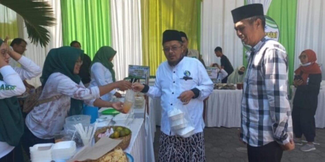 Ketua PCNU Dr. KH. A. Muhyyiddin Khotib dan Kadinsos Situbondo Timbul Surjanto saat melihat bazar UMKM. (ist)