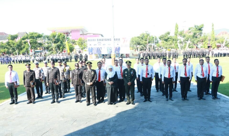 Wabup Sumenep Dewi Khalifah (kerudung putih), didampingi Kapolres Sumenep Edo Satya Kentriko beserta jajarannya, saat upacara Hari Bhayangkara ke 77, Sabtu (1/7/2023). (foto: yusuf)