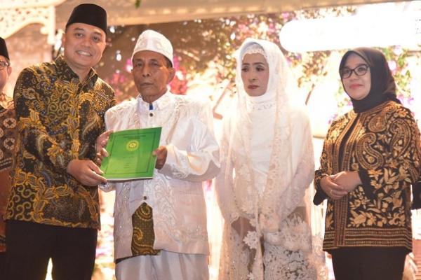 Sah, Pemkot Surabaya Nikahkan 225 Pasangan Secara Massal 1 Wali Kota Surabaya Eri Cahyadi bersama Rini Eri Cahyadi memberikan akta nikah kepada salah satu pasangan nikah massal. (ist)