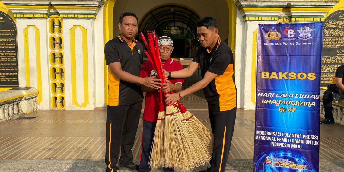 Kanit Regident Polres Sumenep Ipda Aris Wibawa didampingi IPTU M. Rofiq SH, saat bagi - bagi alat kebersihan, didepan tugu gerbang Masjid agung Sumenep