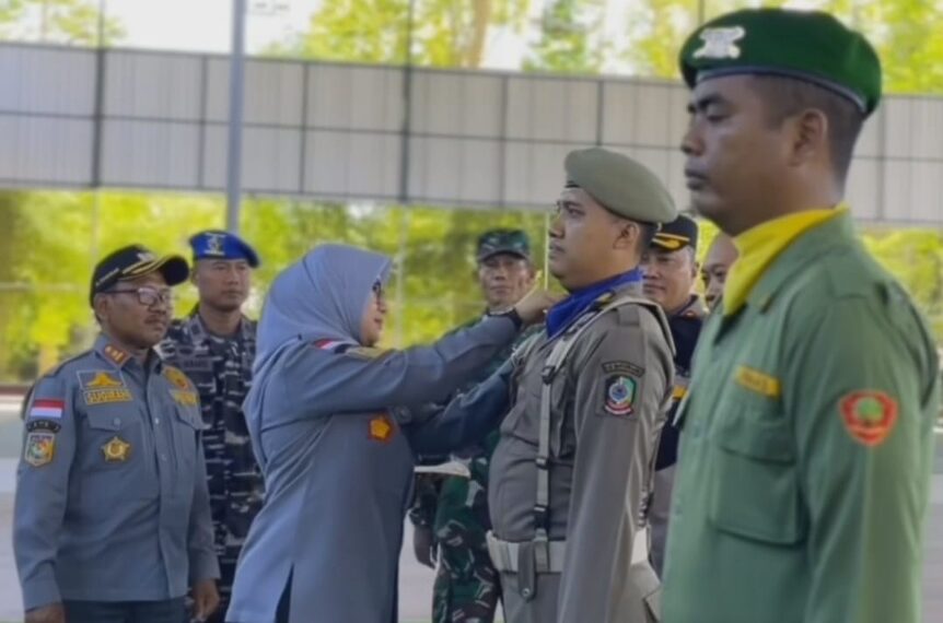 Ipuk Fiestiandani menyematkan pita pengamanan pemilu kepada perwakilan Linmas