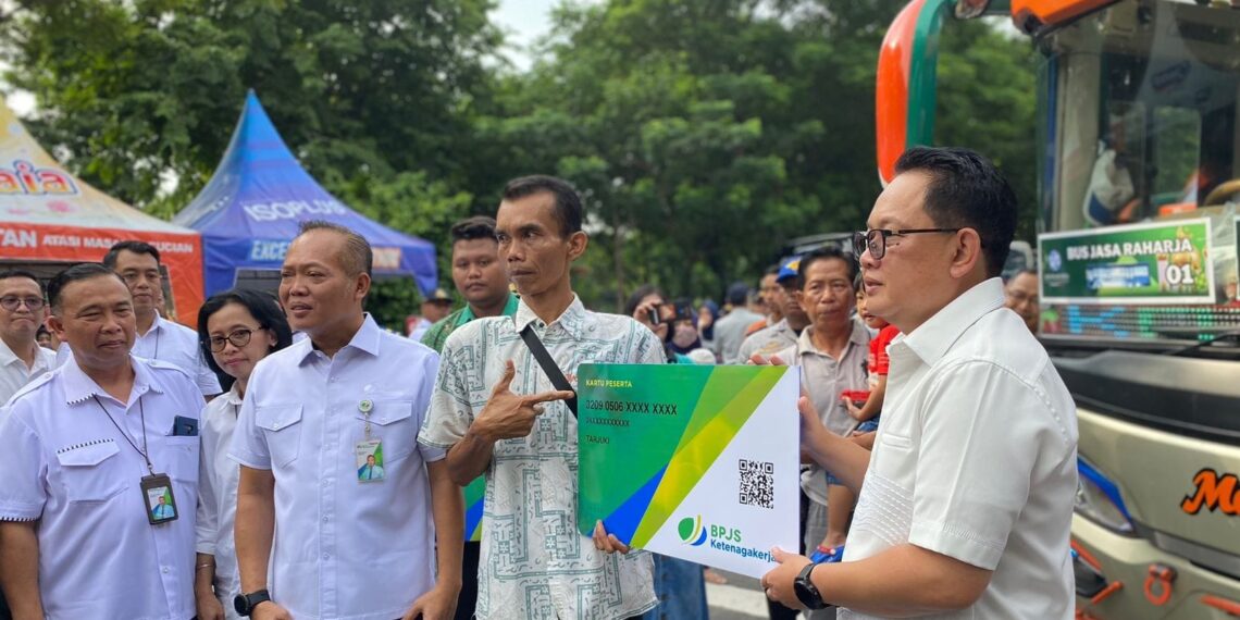 Penyerahan simbolis kartu kepesertaan BPJS Ketenagakerjaan oleh Penjabat (Pj) Gubernur Jatim Adhy Karyono (kanan) & Kakanwil BPJS Ketenagakerjaan Jatim Hadi Purnomo (3 kanan) kepada perwakilan awak bus. (foto2: hari/bidik.news)