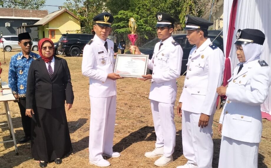 Camat Balongpanggang, Suryo Wibowo saat memberikan piagam terbaik pelunasan PBB ke Kades Ngampel