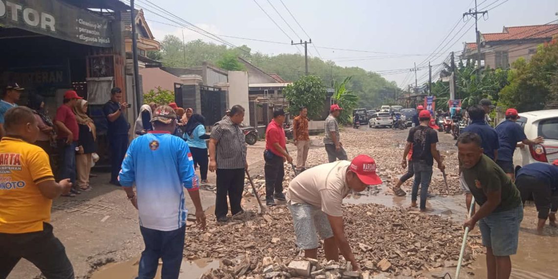 Caption: Paslon Bupati dan wakil Bupati Tulungagung, H. Maryoto Birowo dan Didik Girnoto Yekti (Mardinoto) berbaur dengan Relawan dan warga sekitar Saling bahu membahu, bergotong royong memperbaiki jalan rusak di jl. raya Desa Ngentrong kecamatan Campur Darat, pada Minggu (17/11/2024)