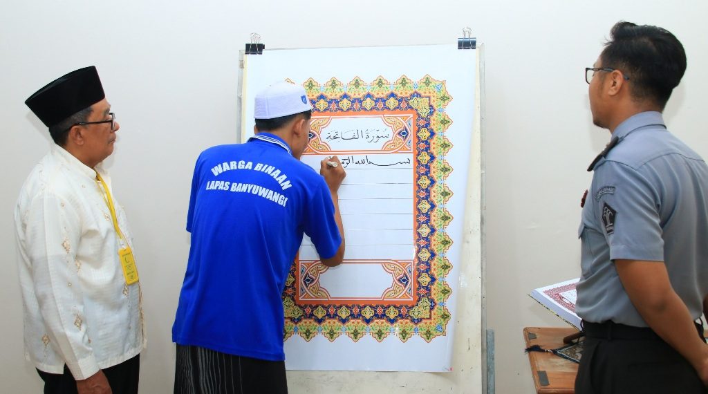 Salah seorang warga binaan Lapas Banyuwangi saat menulis Al-Qur’an raksasa