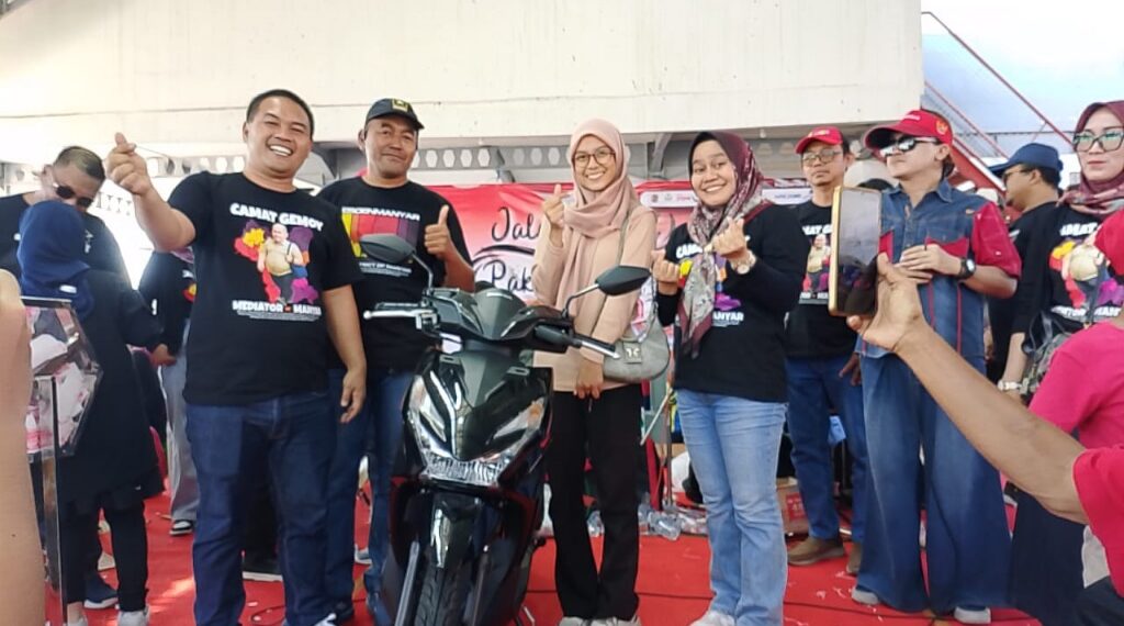 Camat Manyar Susilo Hendrawan bersama istri saat memberikan hadiah motor saat jalan sehat kemerdekaan