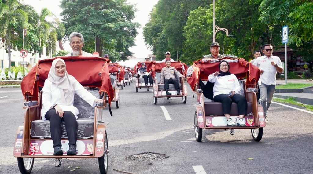200 Lansia di Banyuwangi Terima Becak Listrik, Bupati Ipuk : Jaga dan Rawat dengan Baik 1 Usai prosesi penyerahan, Bupati Ipuk Fiestiandani saat mencoba menaiki becak listrik bersama Nanik S Dayeng