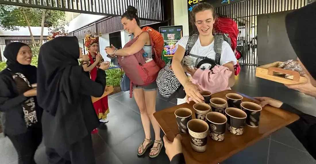 Sambut Kedatangan Wisatawan, Pemkab Banyuwangi Siapkan Minuman dan Kudapan 1 Petugas memberikan minuman dan kudapan kepada wisatawan yang baru datang di Bandara Banyuwangi (Ist)