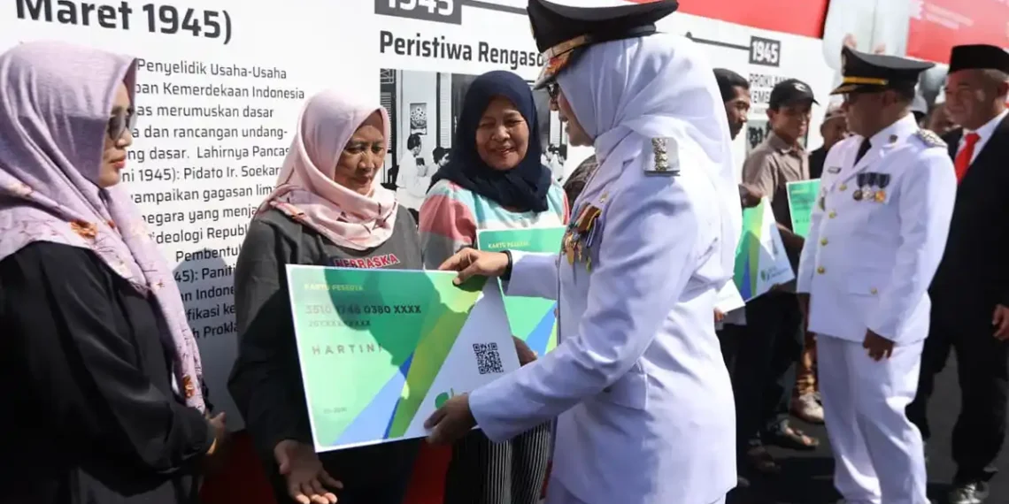 Bupati Ipuk Fiestiandani menyerahkan bukti kepesertaan BPJS Ketenagakerjaan secara simbolis kepada perwakilan pekerja informal di Banyuwangi (Ist)